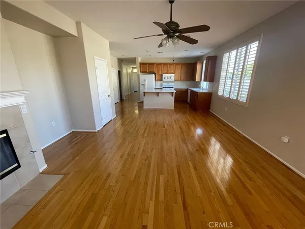 a view of a big room with wooden floor and windows