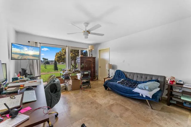 a living room with furniture a ceiling fan and a window