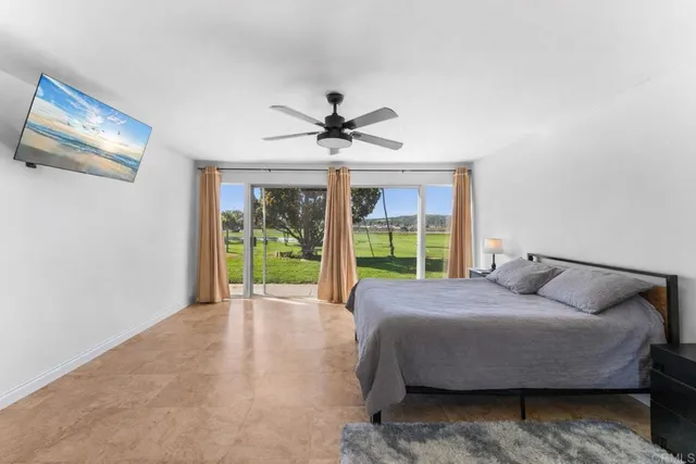 a bedroom with a bed and a large window with balcony view