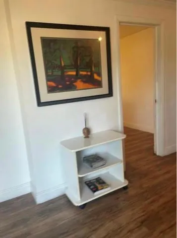 a room with a wooden floor and a painting on the wall