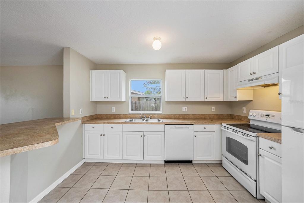 5850 13th Avenue New Port Richey, FL 34652 - Photo 6 of 15 a kitchen with a stove sink and cabinets