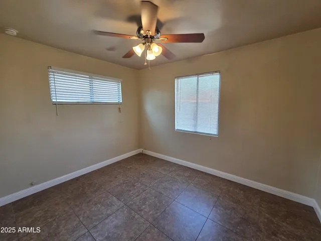 a view of an empty room with a chandelier fan