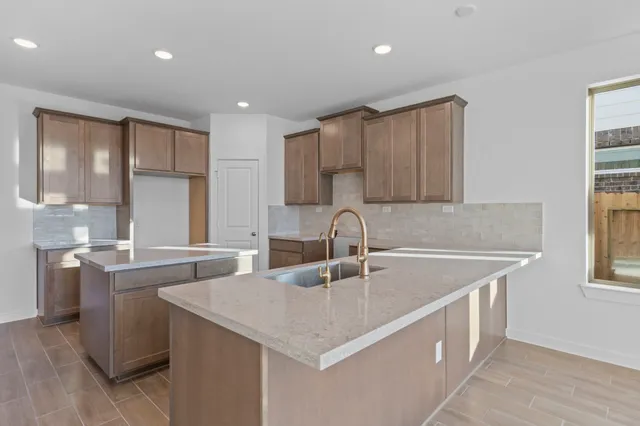 a kitchen with stainless steel appliances granite countertop a sink a stove and a refrigerator