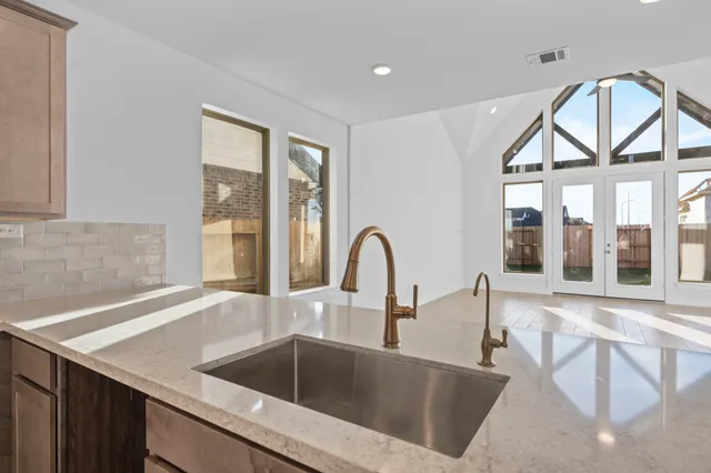 a kitchen with a stove a sink and a large window