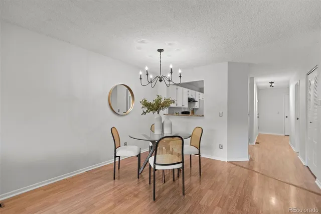 a view of a dining room with furniture a chandelier and wooden floor