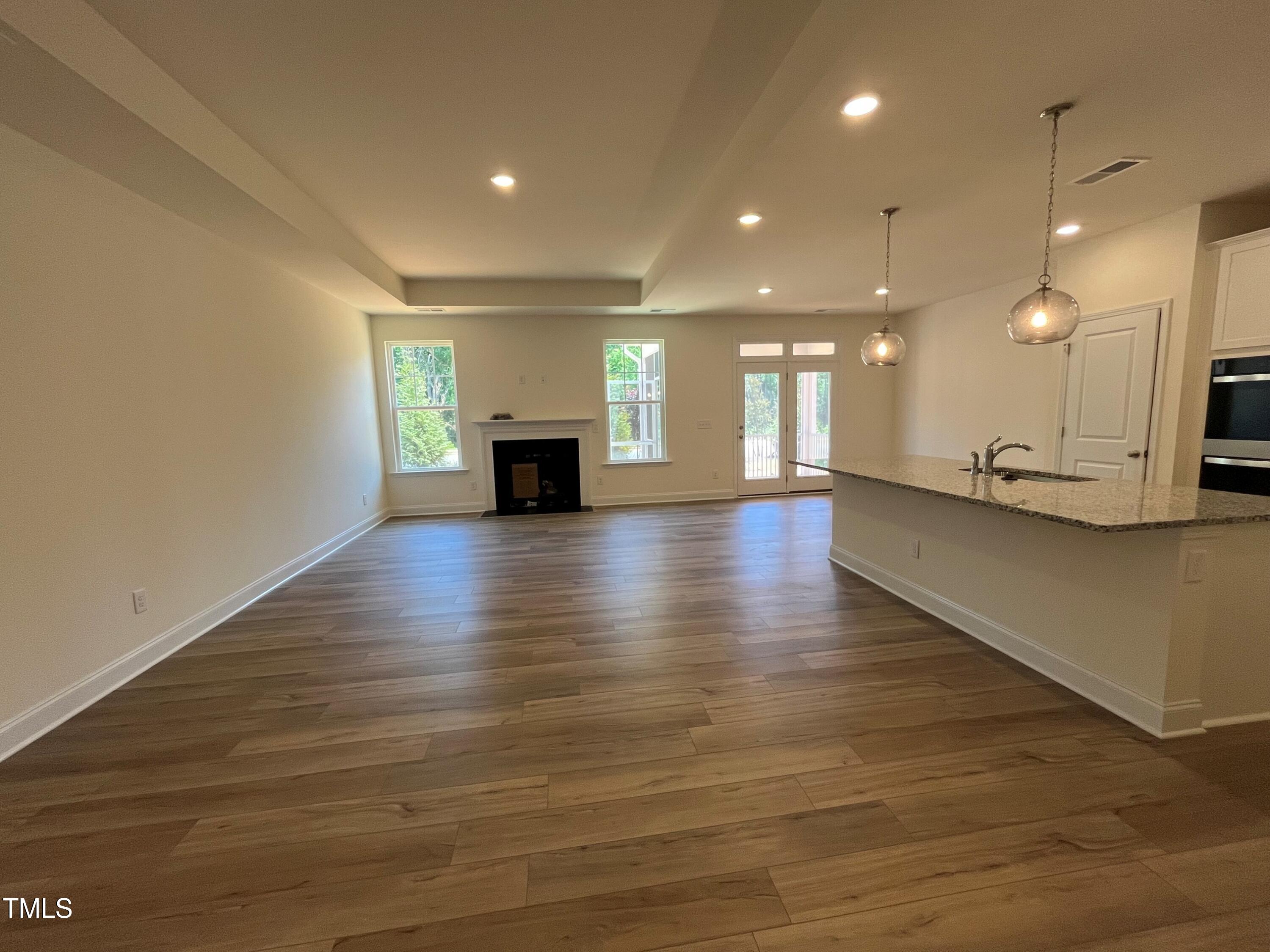 798 Old Station Pointe Angier, NC 27501 - Photo 6 of 19 a view of an empty room with wooden floor and kitchen view