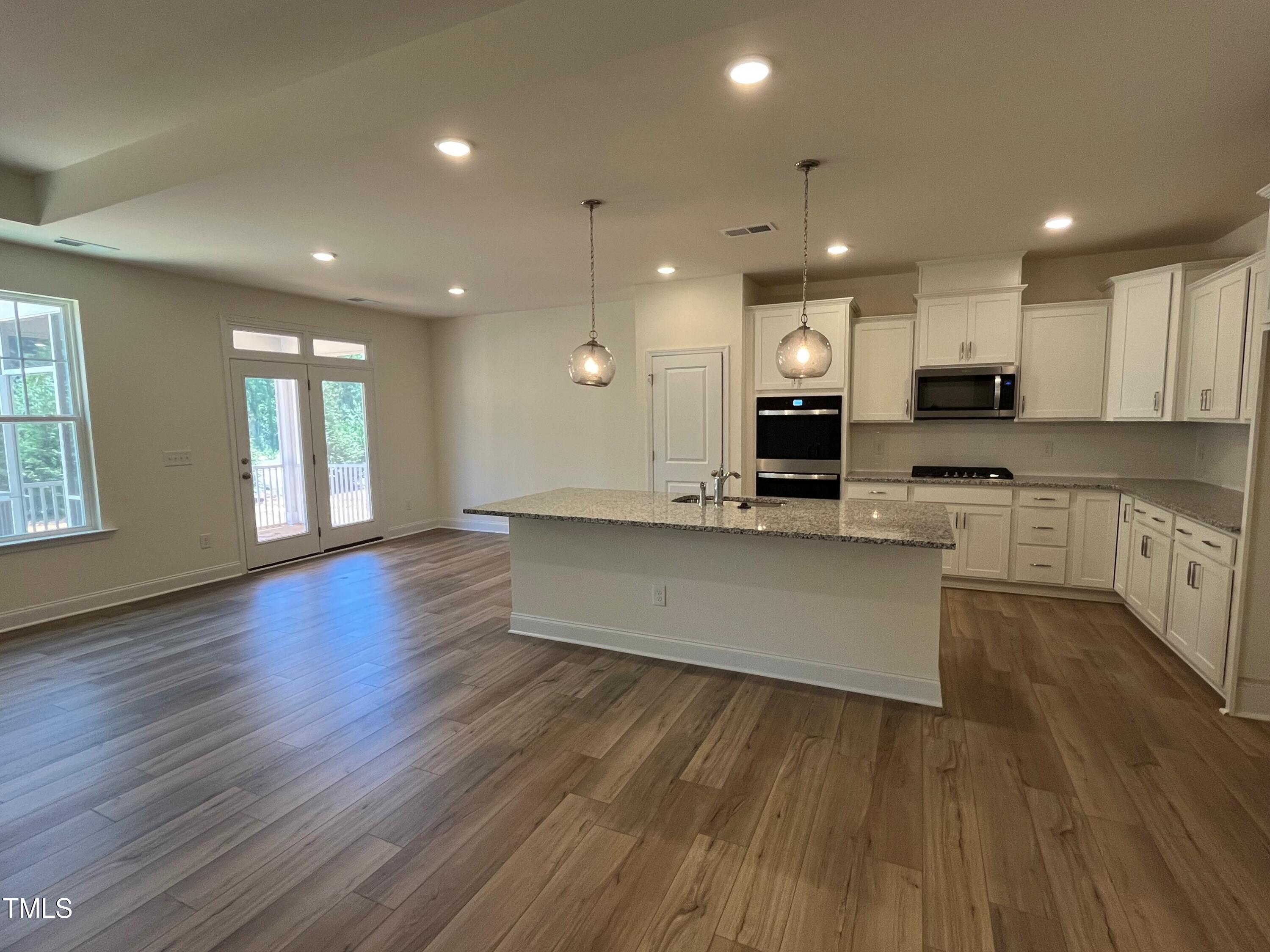 798 Old Station Pointe Angier, NC 27501 - Photo 8 of 19 a large kitchen with stainless steel appliances granite countertop a oven a stove and a wooden floors