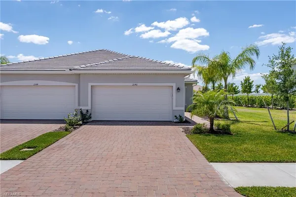 a front view of a house with a yard and a garage