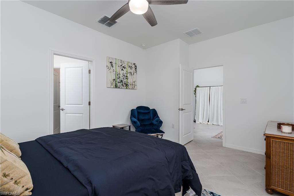 2140 Dragonfruit Way Naples, FL 34120 - Photo 15 of 35 a bedroom with a bed and a chandelier