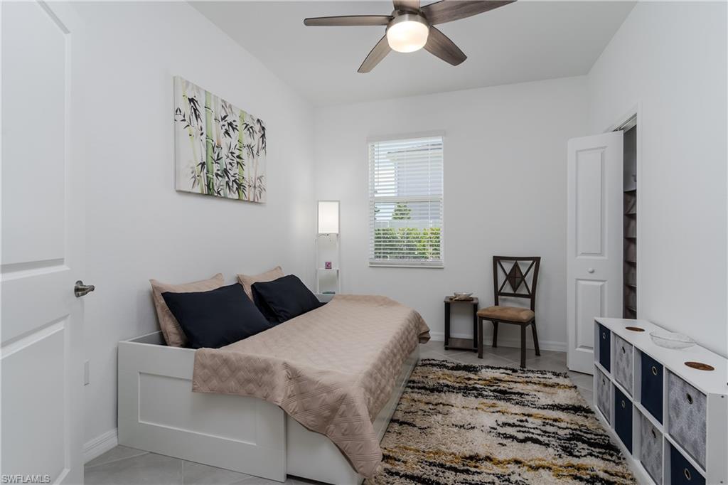 2140 Dragonfruit Way Naples, FL 34120 - Photo 19 of 35 a bedroom with a bed and a chandelier