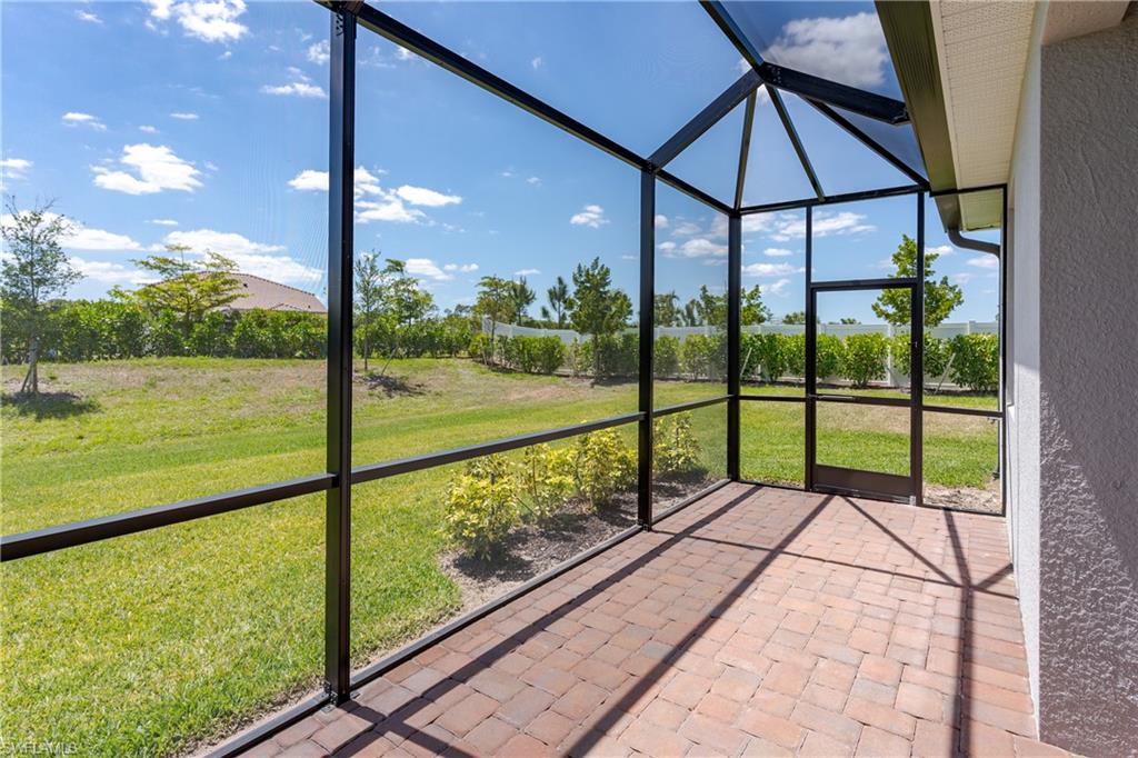 2140 Dragonfruit Way Naples, FL 34120 - Photo 26 of 35 a view of a porch with a floor to ceiling window in the yard