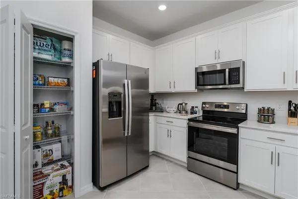 a kitchen with stainless steel appliances granite countertop a refrigerator and a stove top oven
