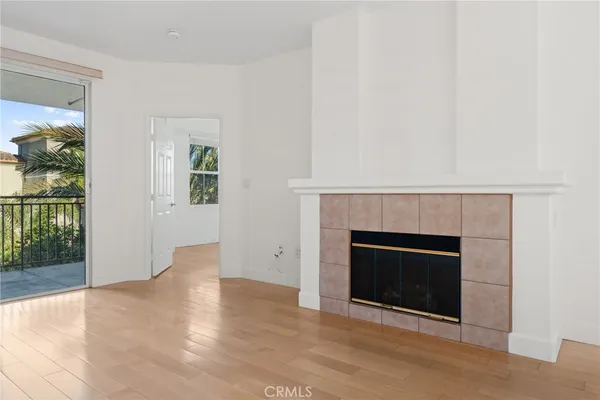 an empty room with fireplace and wooden floor