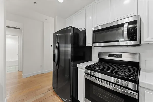 a kitchen with stainless steel appliances kitchen island a stove and a microwave