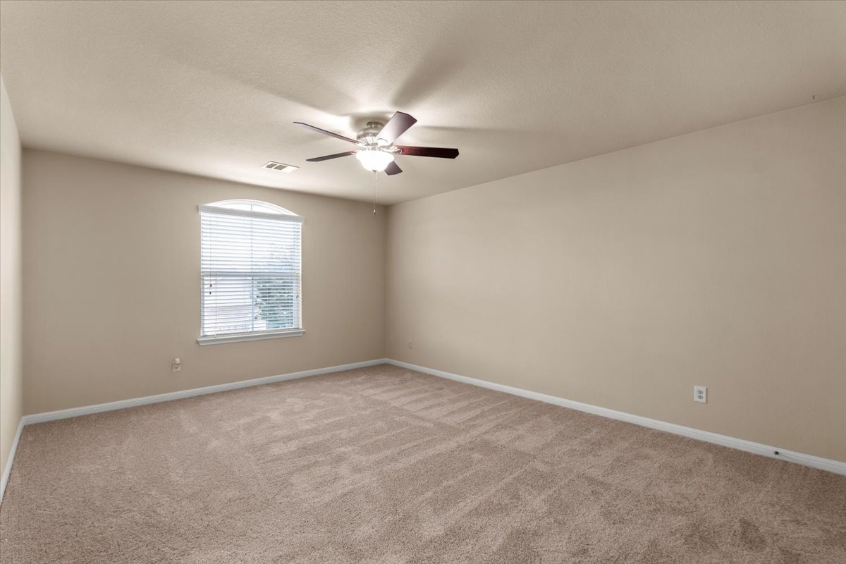 3451 Mayfield Ranch Boulevard, Unit 311 Round Rock, TX 78681 - Photo 31 of 40 Carpeted room featuring a ceiling fan with integrated lighting, an arched window with blinds, and neutral wall paint