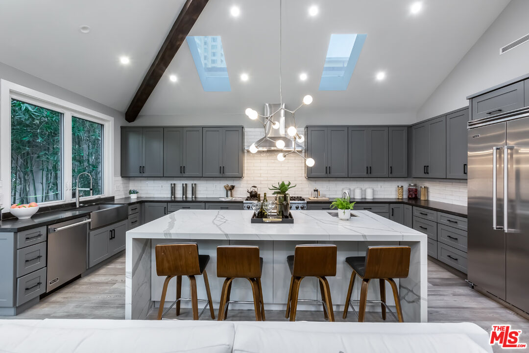 10700 Lindbrook Drive Los Angeles, CA 90024 - Photo 14 of 42 a kitchen with stainless steel appliances granite countertop a kitchen island a stove a table and chairs