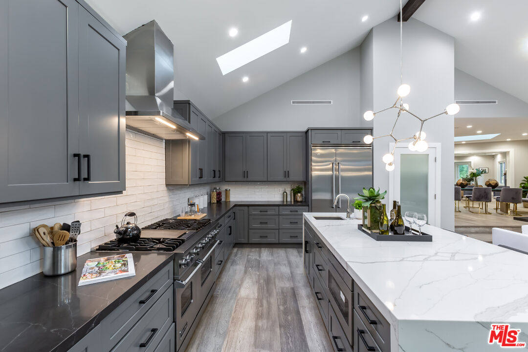 10700 Lindbrook Drive Los Angeles, CA 90024 - Photo 16 of 42 a kitchen with stainless steel appliances a sink stove and cabinets