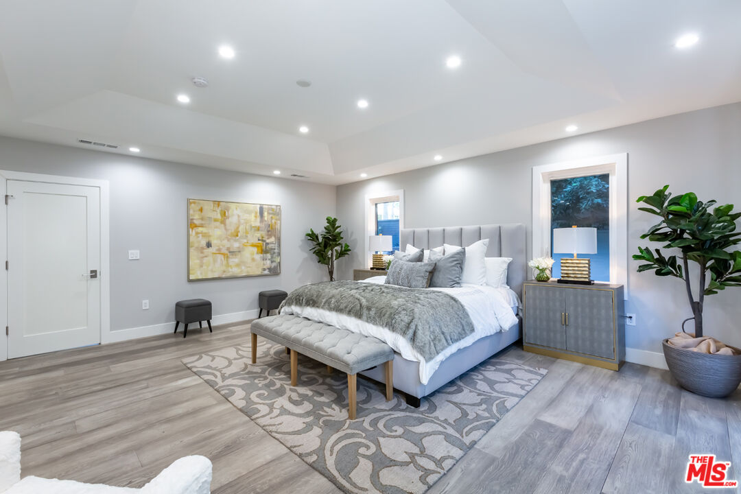 10700 Lindbrook Drive Los Angeles, CA 90024 - Photo 24 of 42 a spacious bedroom with a large bed and a potted plant