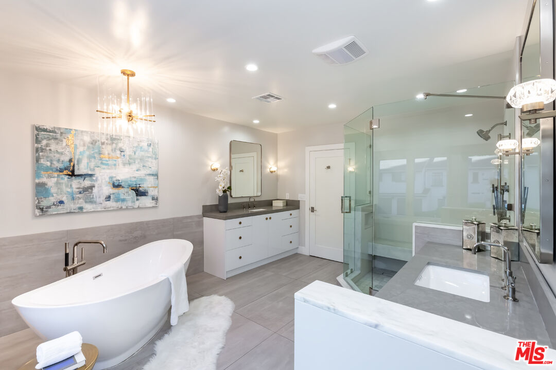 10700 Lindbrook Drive Los Angeles, CA 90024 - Photo 26 of 42 a bathroom with a double vanity sink a toilet a mirror and shower
