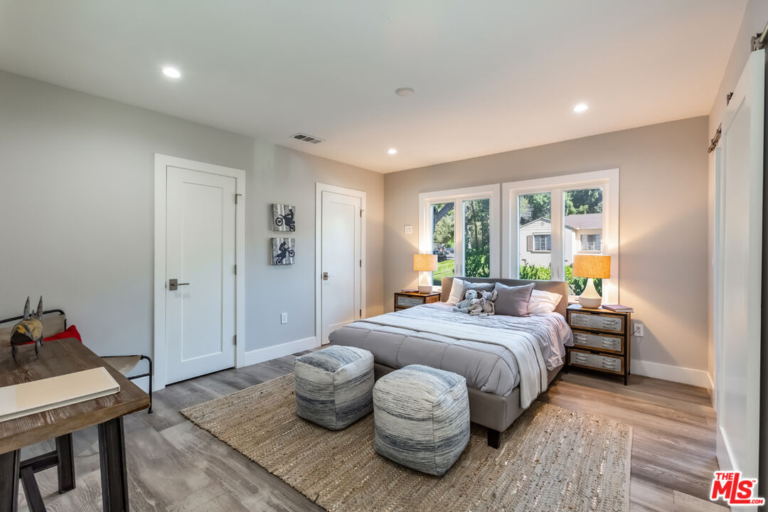 10700 Lindbrook Drive Los Angeles, CA 90024 - Photo 28 of 42 a spacious bedroom with a bed and wooden floor