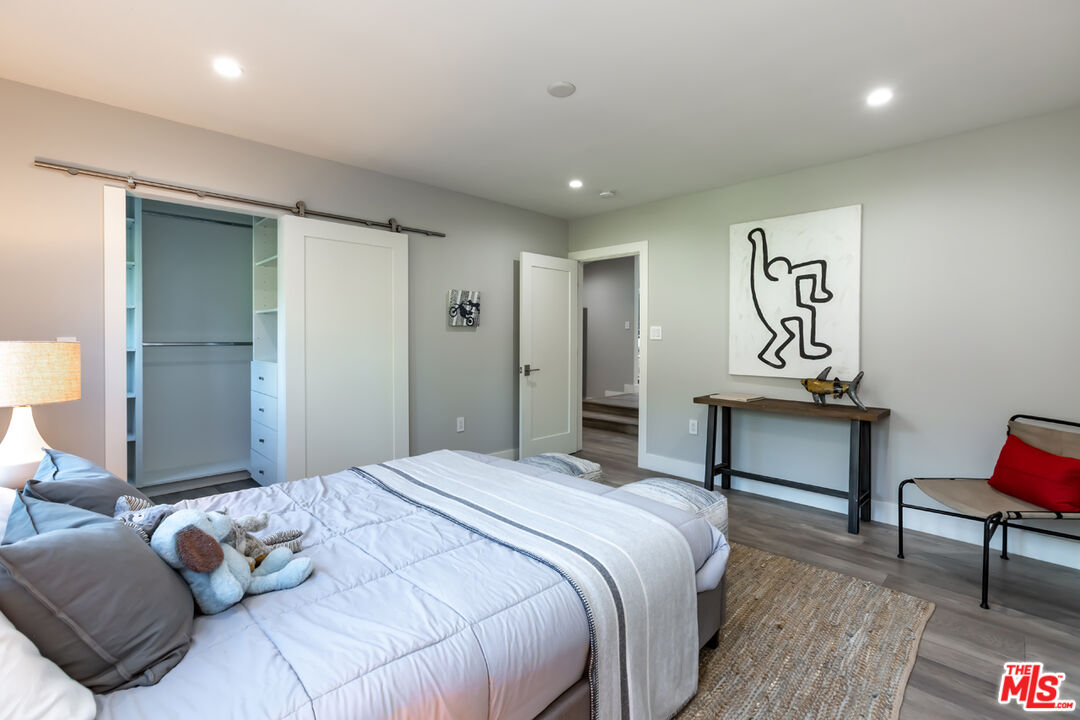 10700 Lindbrook Drive Los Angeles, CA 90024 - Photo 29 of 42 a bedroom with a bed a chair and painting on the wall
