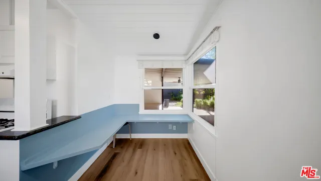 a hallway with wooden floor chandelier and entryway