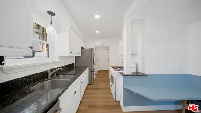 a kitchen with stainless steel appliances granite countertop a sink and a stove