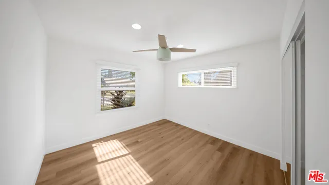 a view of empty room with wooden floor