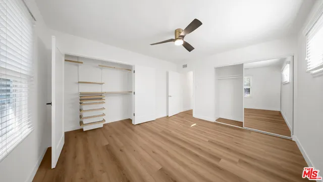 a view of empty room with wooden floor and window