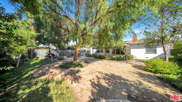 a view of a yard with plants and trees