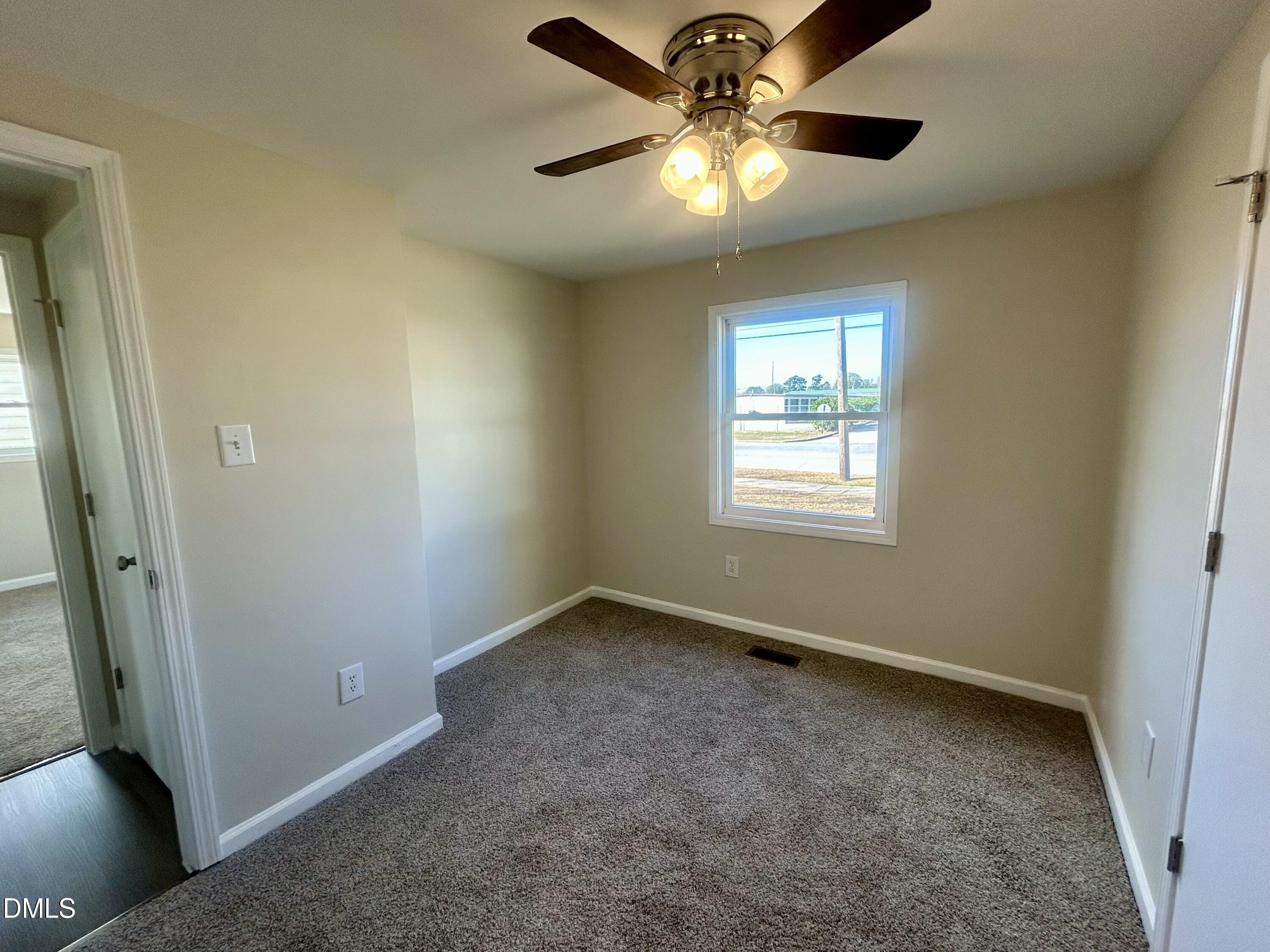 403 South Market Street Benson, NC 27504 - Photo 16 of 18 an empty room with a window and a fan