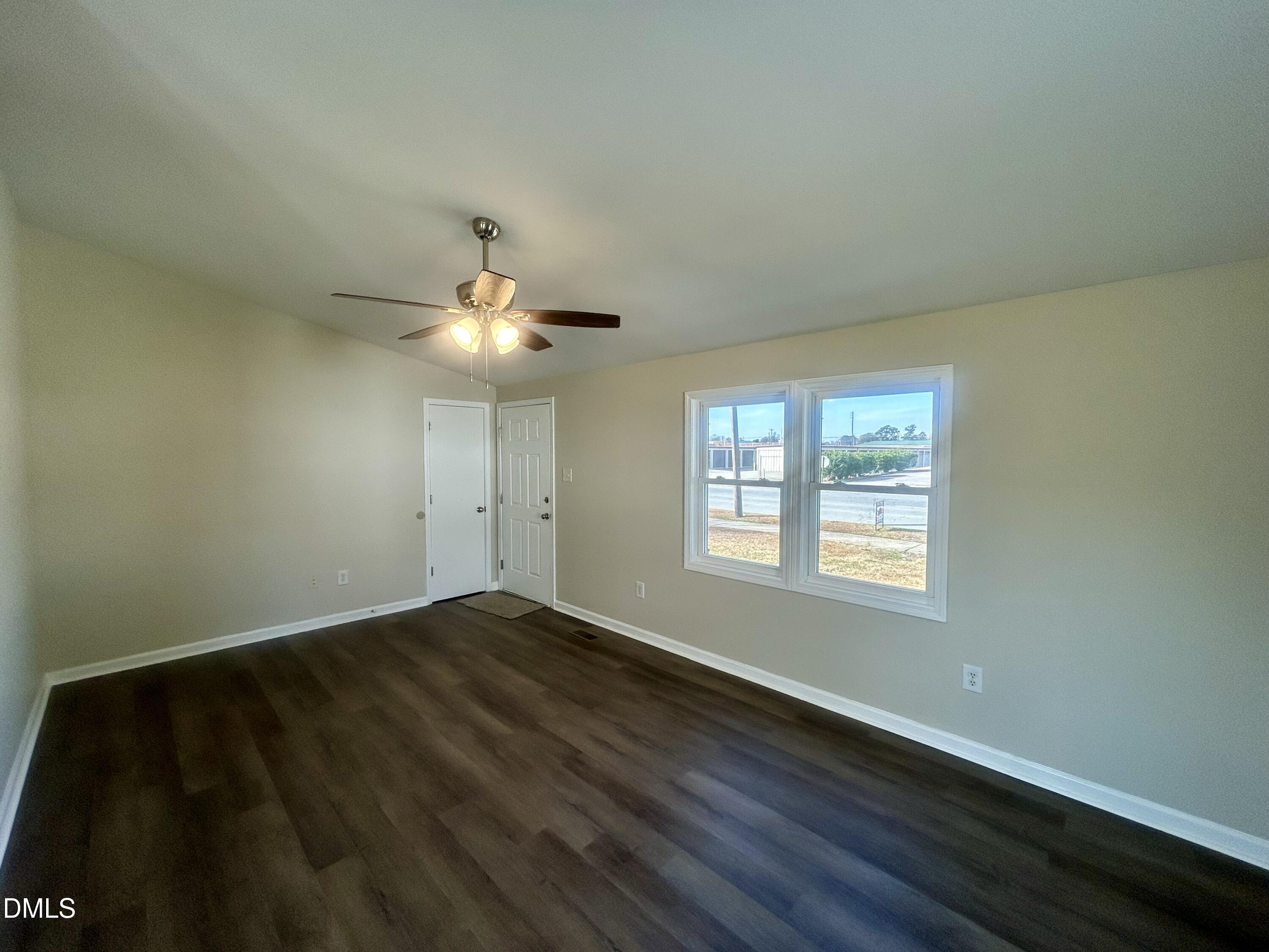 403 South Market Street Benson, NC 27504 - Photo 2 of 18 a view of an empty room with wooden floor and a window