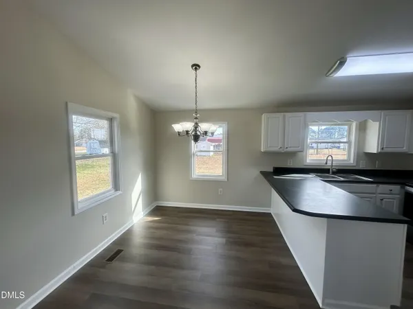 a kitchen with kitchen island granite countertop a stove a sink a refrigerator dining table and chairs