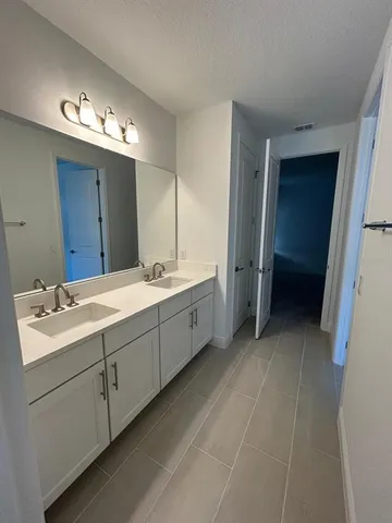 a bathroom with a double vanity sink and mirror