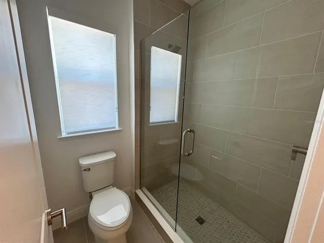 a white toilet next to a bathroom