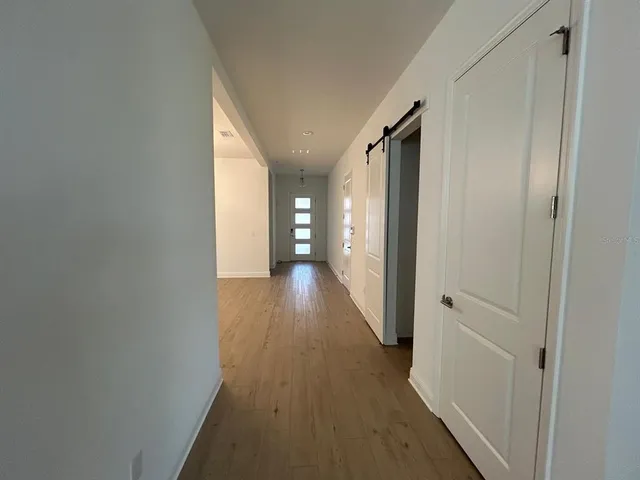 a view of a hallway with wooden floor