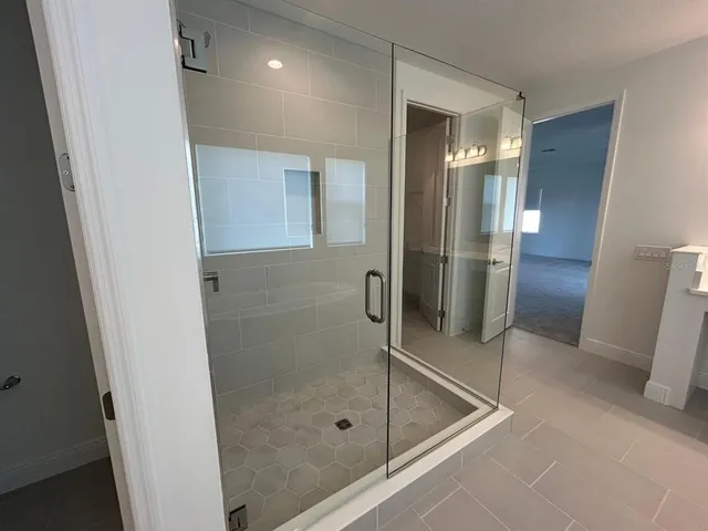 a bathroom with a shower and a glass door