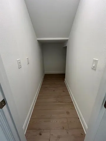 a view of hallway with wooden floor