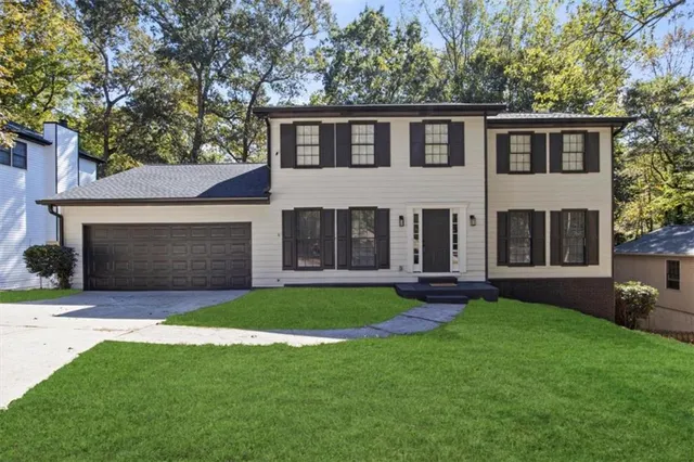 a front view of a house with a garden and yard