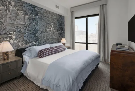 a bedroom with a bed and a flat tv screen on the dresser