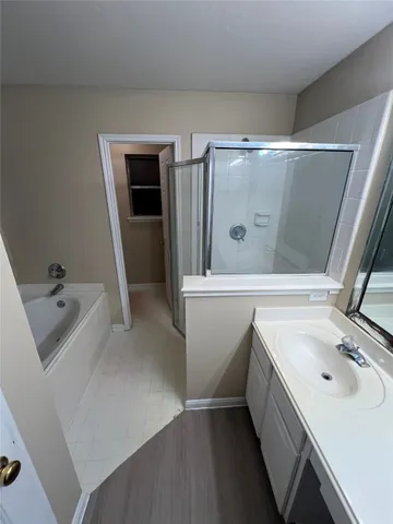 a bathroom with a sink and mirror with bathtub
