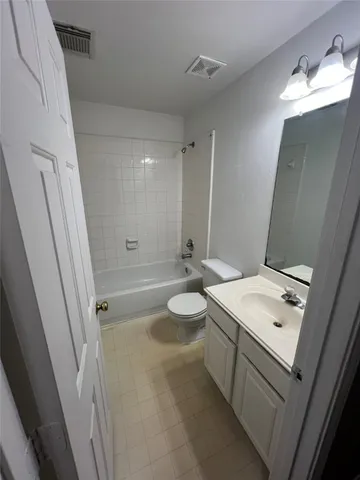 a bathroom with a sink a toilet a mirror and shower