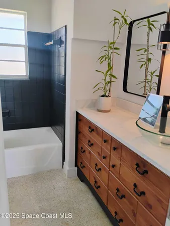 a bathroom with a tub sink and mirror