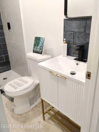 a white toilet sitting next to a white sink