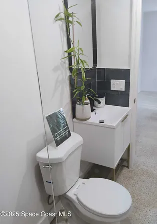 a white toilet sitting next to a bathroom sink