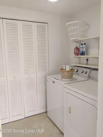 a utility room with cabinets washer and dryer