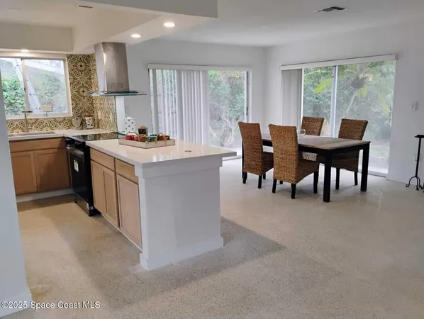a kitchen with a table chairs sink and cabinets