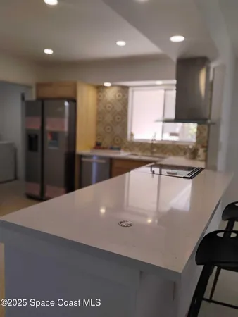 a large kitchen with stainless steel appliances a large counter top