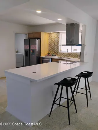 a large kitchen with stainless steel appliances kitchen island granite countertop a sink and a stove