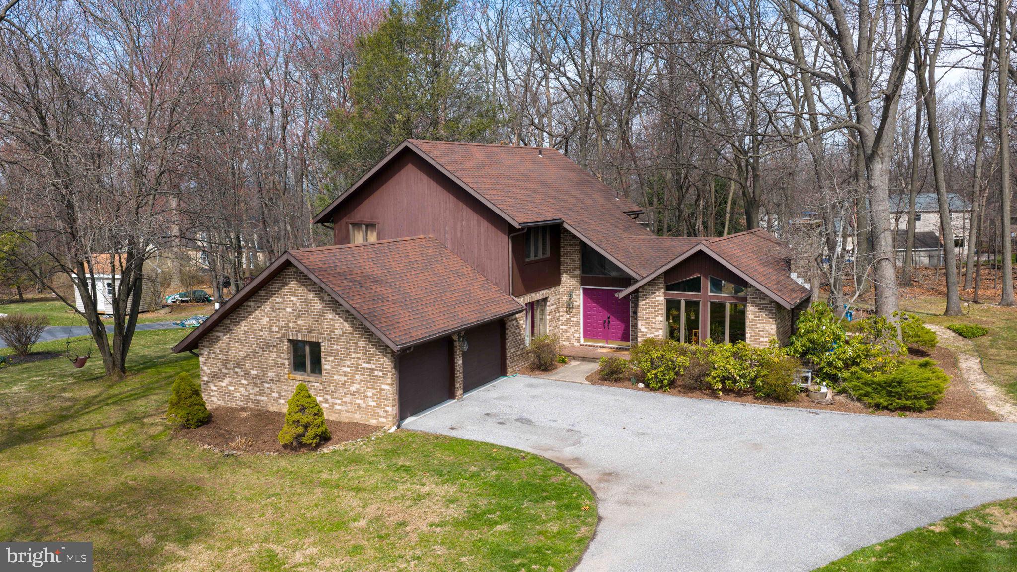 a view of a house with a yard and large tree